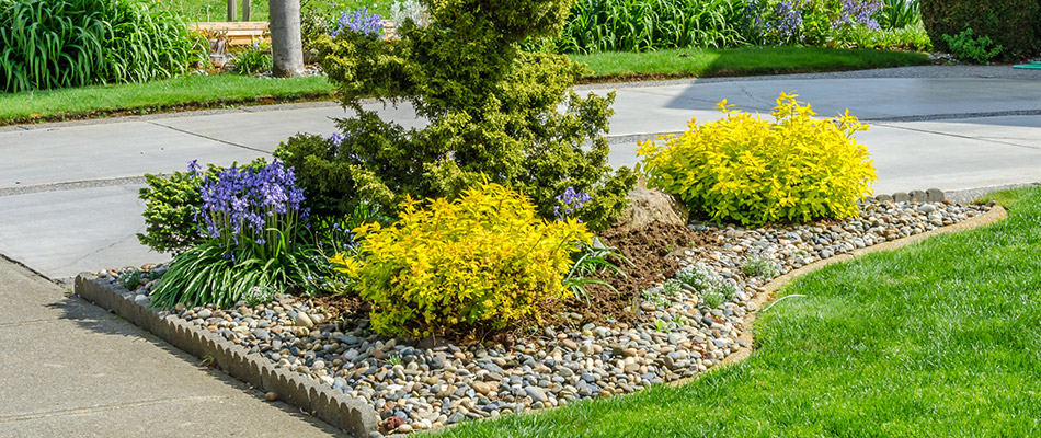 A landscape bed topped with rock on a property in Edwardsburg, MI.